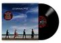„U2 Carnaval de Luz“; Kreistext: „The new studio album... Dolly Parton“. Vier Personen gehen am Strand, Himmel im Hintergrund.
