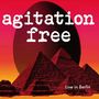 „agitation free“ oben, „Live in Berlin“ unten. Rote Pyramiden und großes Ei auf einem orange-pinkem Hintergrund.