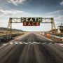 "DEATH RACE" leuchtet über Start-Ziellinie, Rennstrecke in ländlicher Umgebung, Werbebanner entlang der Strecke.