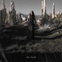 Text: "the dark". Eine Person in schwarzem Kleid steht in einer felsigen Landschaft mit bizarren, hohen Steinformationen.
