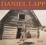 "Daniel Lapp. Woodbox Records WR002. Hardwood Sessions Vol. 1." Ein Mann steht vor einer Holzblockhütte im Schnee.