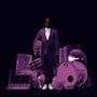 Ein Mann in einem Anzug steht umgeben von lila Instrumenten wie Schlagzeug und Keyboards vor einem dunklen Hintergrund.