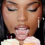 MENTISSA, Frau mit geschlossenen Augen öffnet Mund vor zwei Cupcakes, einer mit Kirsche. Lippen glänzend.