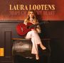 Text: "LAURA LOOTENS SHAPE OF MY HEART". Frau mit Gitarre sitzt auf antiker Kommode, elegantes Ambiente.