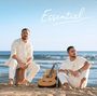 Text: "Essentiel". Zwei Männer in weißer Kleidung am Strand mit Gitarre zwischen ihnen, sitzen vor dem Meer.