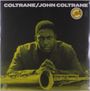 Text: "COLTRANE/JOHN COLTRANE". Eine ernst blickende Person lehnt sich über ein Saxophon. Gelb getöntes Cover.