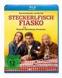 "STECKERLFISCH FIASKO" in roten Buchstaben, darunter Personen an einem Tisch mit einem Hund, gelbem Hintergrund.