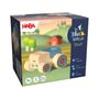 "HABA", "My 1st Block World", "Farm Life", "1+", "2 PCS", "Made in Germany". Holzspielzeug-Traktor, Landschaft im Hintergrund.