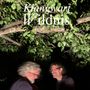 Text: "Klangwart Wildnis." Zwei Männer stehen unter einem belaubten Baum, einer lächelt, der andere ist unscharf.