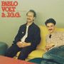 Text: "Pablo Volt & J.G.G." und "Aquí me quedo". Zwei Männer sitzen auf einem gelben Sofa, der Hintergrund ist blassgrün.