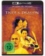 "Tiger & Dragon" in weißen Buchstaben, darunter drei Personen mit Schwertern, orangefarbener Hintergrund, FSK 12 Logo.