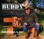 "BUDDY. COWBOYSTIEFEL & HUT." Ein Mann mit Cowboyhut sitzt auf einer Bank neben einem kleinen Hund bei sonnigem Wetter.