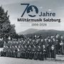 "70 Jahre Militärmusik Salzburg 1956-2026" zeigt eine historische Militärkapelle in Uniformen vor einem landschaftlichen Hintergrund.