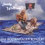 „Sandy Wolfrum“, „DAS BOLTENHAGEN KONZERT“, „das komplette Konzert im Rahmen der 25. Liedertage 2023.“  
Ein Mann spielt Gitarre auf einem Floß mit Rumfass und Piratenflagge.