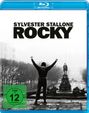 "Sylvester Stallone Rocky" in großen Buchstaben. Darunter eine Figur mit erhobenen Armen auf Treppen; FSK 12 Logo.