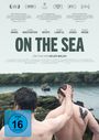 „ON THE SEA“, ein Film von Helen Walsh. Zwei Männer am Wasser, einer mit Adler-Tattoo. FSK 16 Zeichen unten links.