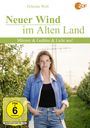 Felicitas Woll, ZDF-Logo, "Neuer Wind im Alten Land", FSK 6, Frau in blauem Mantel, ländlicher Hintergrund mit Obstbäumen.