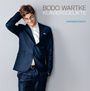 Text: "Bodo Wartke Klaviersdelikte Wiederentdeckt". Ein Mann im Anzug lächelt und greift sich in die Haare.