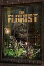 Text: "THE FLORIST". Ein Schaufenster zeigt Blumen und subtil ein Gewehr im Hintergrund.