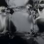 Keine Texte sichtbar. Dunkle, glänzende Oberfläche mit reflektierenden, verzerrten rechteckigen Formen und Linien.