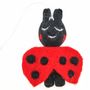 Eine Filzfigur in Schwarz und Rot, die einen Marienkäfer darstellt. Sie hat Punkte und eine Schnur zum Aufhängen.