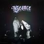 Text: "SÉANCE GET WELL SOON". Eine Illustration mit einer mystischen Szene: Eine Person liegt im Vordergrund, umgeben von Menschen und geisterhaften Figuren.