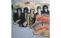 "TRAVELING WILBURYS" oben und auf einem alten Plakat mit fünf Männern in Sonnenbrillen. Retro-Stil.