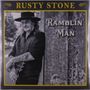 Text: "RUSTY STONE" oben, "RAMBLIN 'MAN" rechts. Schwarz-weißes Foto eines Mannes mit Gitarre an einem Baum.