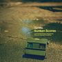 "Sunken Scores: Lost Themes & Jazzy Sequences from the Cinematic Coastlines". Ein grünes, altes Gerät auf nassem Asphalt.