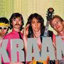 Text: "KRAAN", "ALBUM TAPES". Vier Männer, einer mit Gitarre. Bunte Kleidung, fröhliche Ausstrahlung vor glitzerndem Hintergrund.