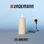 „Lindemann“ und „Es brennt...“. Eine elektrische Kerze ist an eine Steckdose angeschlossen.