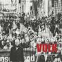 "WER IST DAS VOLK" und "PAUL BARTSCH & BAND" in weiß und rot. Illustration einer Menschenmenge, unscharf und strukturiert.