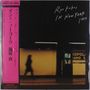 Japanische Zeichen links, „Ryo Fukui In New York 1999“ oben rechts, Person geht vor gelblichem Hintergrund.