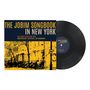 "THE JOBIM SONGBOOK IN NEW YORK" in großen Buchstaben. Darunter "THE DAVID HAZELTINE TRIO" auf einem Albumcover.