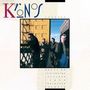 Text: "Kronos Quartet, music by Scelsi, Partch, Riley, J. Hendrix." Vier Männer stehen draußen vor einem gelben Gebäude.