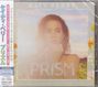 "PRISM" und "KATY PERRY" in weißen Buchstaben. Frau vor Blumenfeld in sanften Farben, Hände am Gesicht.