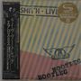 Japanischer Text auf schwarzem Balken links. "SMITH LIVE" oben. Logo mit Flügeln und "AEROSMITH". "BOOTLEG" diagonal unten.
