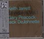 „Keith Jarrett Standards, Vol. 1 Gary Peacock Jack DeJohnette“ in blauer Schrift auf braunem Hintergrund. Links ist ein vertikaler Streifen mit japanischen und englischen Texten.
