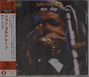 "John Coltrane sun ship". Links japanischer Text. Verschwommene Nahaufnahme von jemandem, der ein Saxophon spielt.