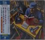 Links Text in japanischen Schriftzeichen, darunter "King Crimson", "The Night Watch Live 1973". Rechts ein Mann mit Buch.