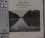 "Bill Evans The Paris Concert edition two." Schwarz-weiß Foto: ruhiger Fluss in bewaldeter Landschaft.
