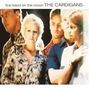Text: "first band on the moon THE CARDIGANS". Verschwommene Gruppe von fünf Personen in gemusterten Kleidern.