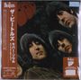 Zu sehen sind vertikale japanische Schriftzeichen und "THE BEATLES" in einem Logo. Vier Personen mit Pilzkopf-Frisuren.
