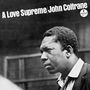 Text oben: "A Love Supreme/John Coltrane". Schwarz-weißes Foto eines nachdenklichen Mannes, der zur Seite schaut.