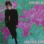 Text: "KIM WILDE" und "ANOTHER STEP". Eine Frau steht vor einer bunten Weltkarte.