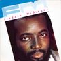 Der Text "Freddie McGregor" in Rosa, "FM" in Hellblau, Porträt eines Mannes mit Bart und ruhigem Blick.