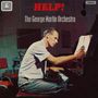 Text: "HELP!", "The George Martin Orchestra". Ein Mann sitzt am Klavier und schreibt Noten auf ein Blatt Papier.