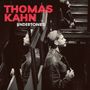 "THOMAS KAHN UNDERSONES" in roten und weißen Buchstaben, zeigt einen Mann in einem Treppenhaus mit Spiegeln.