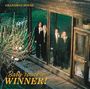 „GRANDMAS HOUSE“ oben links, „Baby You're a WINNER!“ unten links. Vier Personen in Anzügen stehen hinter Glas.