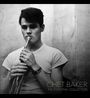 Text: "Chet Baker: The Essential Collection". Ein junger Mann in einem T-Shirt hält eine Trompete an seinen Lippen.